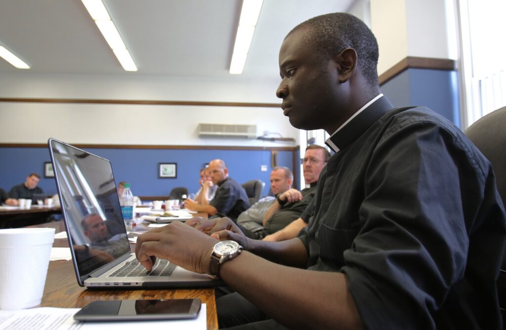 Piarist Father Andrew Mbinkar of Cameroon uses a laptop computer during a presentation by Father Peter M.J. Stravinskas, executive director of the Catholic Education Foundation, at Immaculate Conception Seminary in Huntington, N.Y.