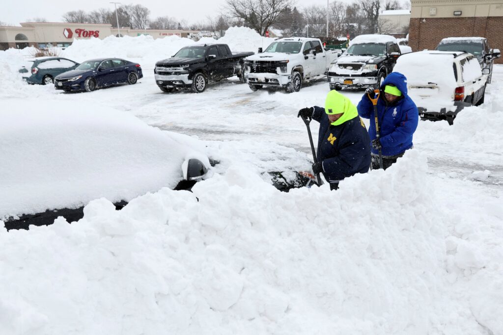 People work to dig out a car in Amherst, N.Y., Dec. 26, 2022, during a deadly winter storm that hit the Buffalo region.