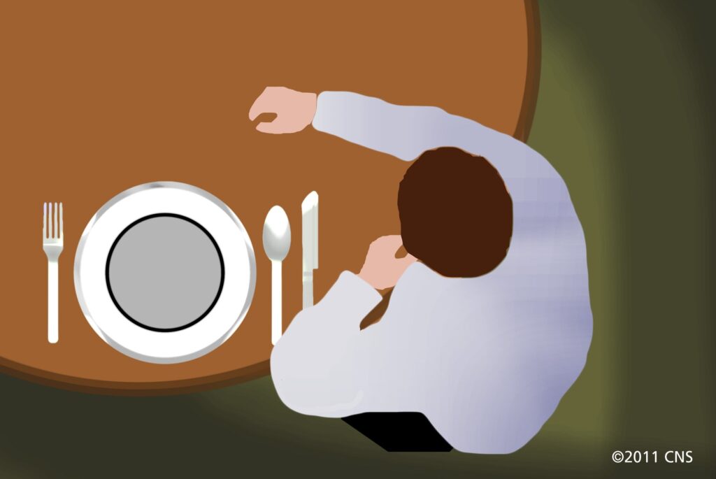 A drawing of a man sitting at an empty place setting, symbolizing fasting.