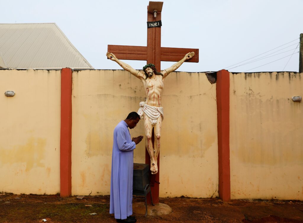 Father Paul Obayi prays in front of the crucifix at St. Mary's Cathedral in Enugu, Nigeria, Sept. 30, 2021.