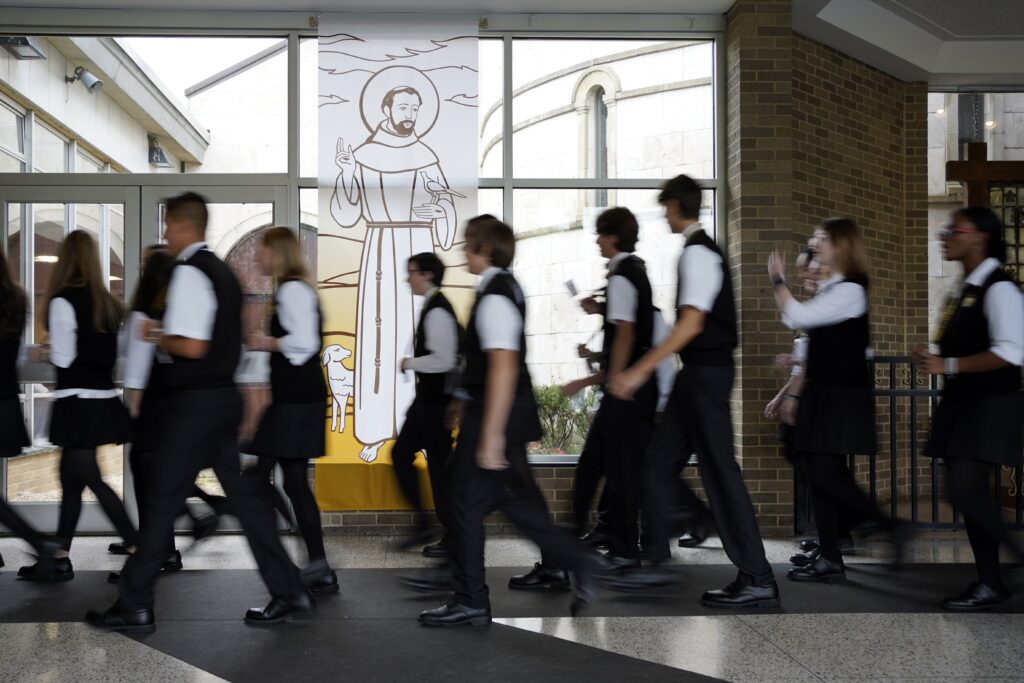Students pass a banner of St. Francis of Assisi as they walk to a Mass marking the saint's feast day at Franciscan-run St. Anthony's High School in South Huntington, N.Y., Oct. 4, 2022.