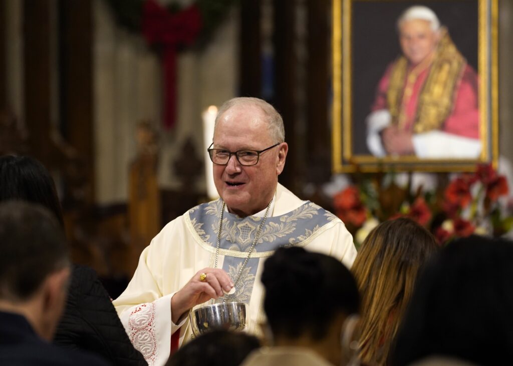 New York Cardinal Timothy M. Dolan distributes Communion as he celebrates Mass for the repose of the soul of Pope Benedict XVI at St. Patrick's Cathedral in New York City Jan. 1, 2023.