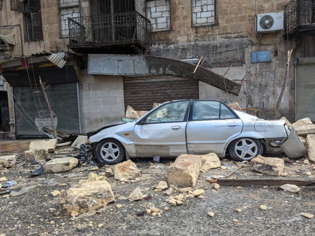 A crushed car is seen in Aleppo, Syria, Feb. 7, 2023, one day after two powerful earthquakes destroyed buildings and killed thousands in the region along the border of Turkey and Syria.