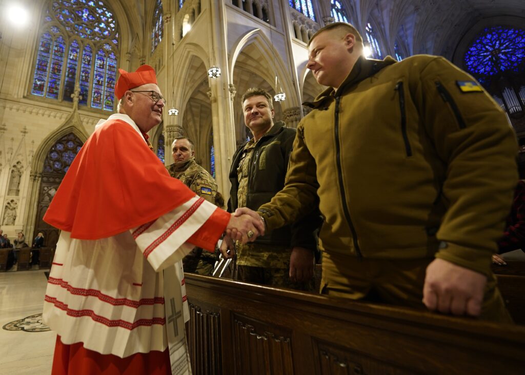 New York Cardinal Timothy M. Dolan greets wounded Ukrainian soldiers, who are receiving medical care in the U.S. for their war injuries, at the beginning of an ecumenical prayer service for peace in Ukraine at St. Patrick's Cathedral in New York City Feb. 18, 2023.