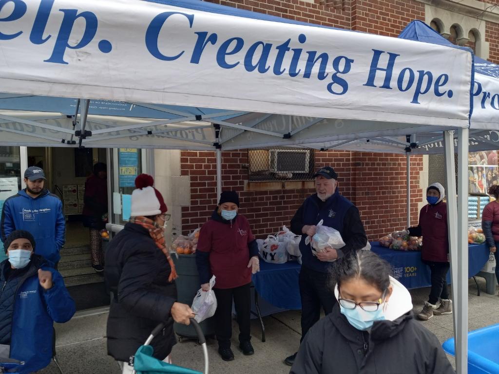 Msgr. Kevin Sullivan (wearing cap) helps distribute food on Ash Wednesday morning outside the rectory of St. Cecilia's parish in East Harlem.