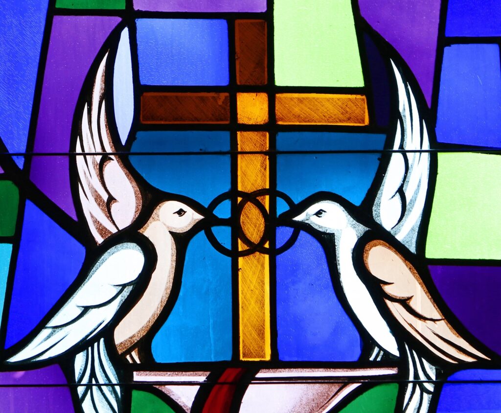 Palomas y anillos de boda entrelazados que simbolizan el sacramento del matrimonio se ven en un vitral de la Iglesia Sts. Cyril y Methodius en Deer Park, N.Y.