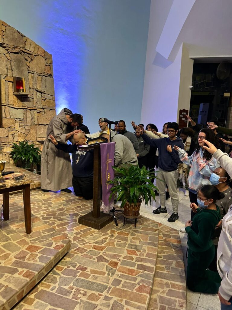 Priests, lay ministers and event participants pray over Bishop Espaillat before he preaches Ash Wednesday night at Holy Cross parish in the Bronx.