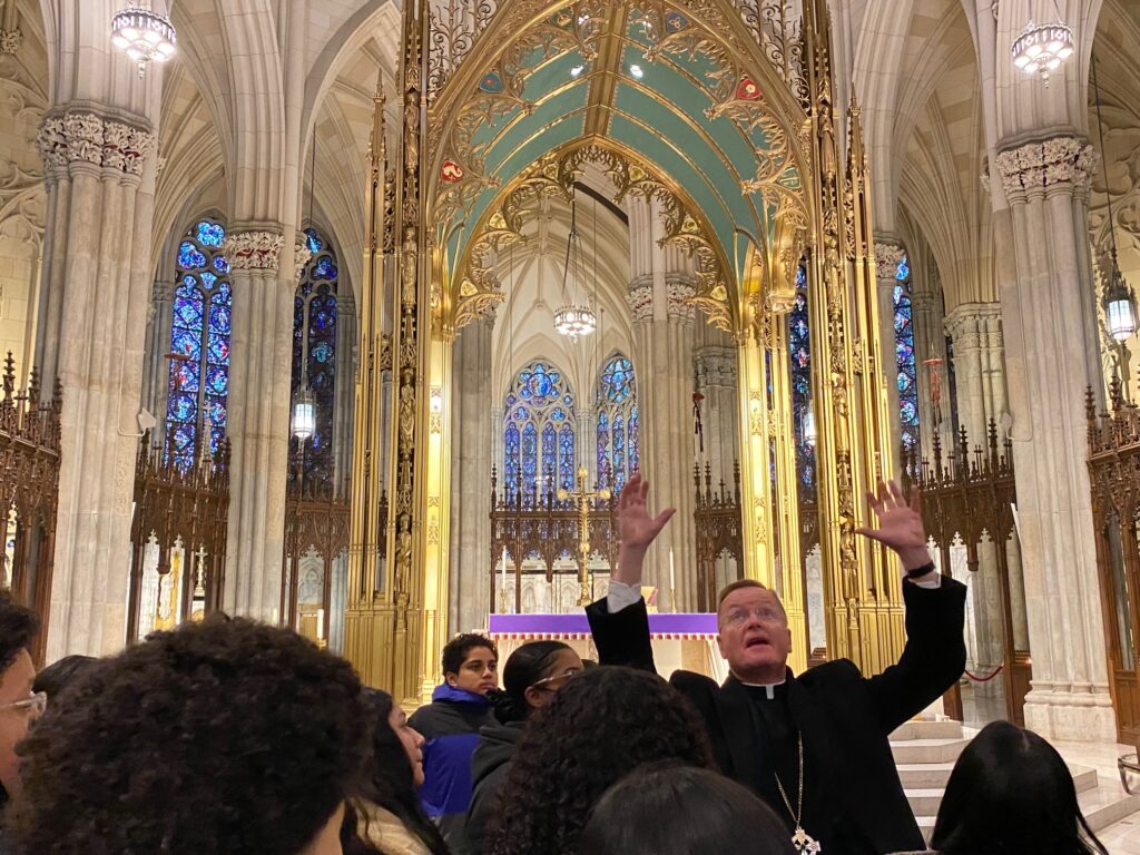 Bishop Edmund J. Whalen explains the symbols used at St. Patrick's Cathedral to a group of students from St. John Chrysostom in the Bronx, March 15, 2023.