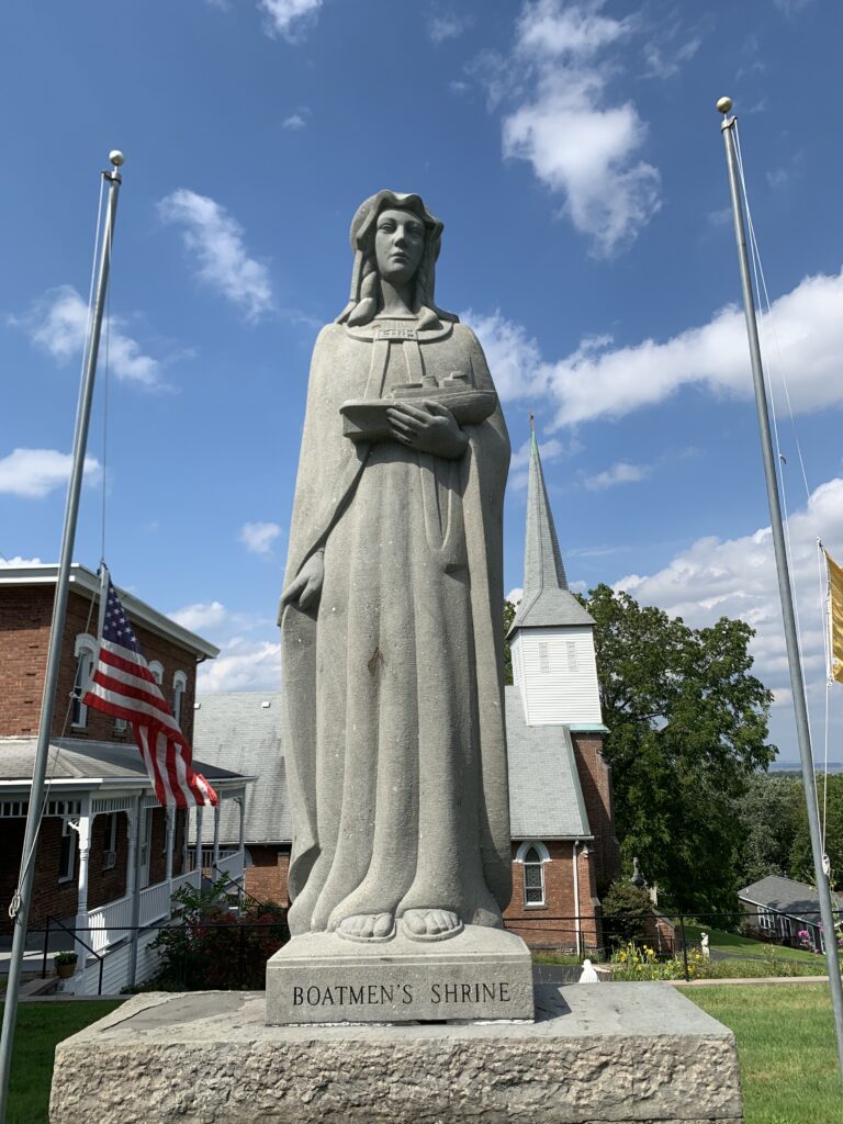 The Shrine of Our Lady of the Hudson, a six-foot blue stone statue of the Virgin Mary holding a tugboat in her arms.