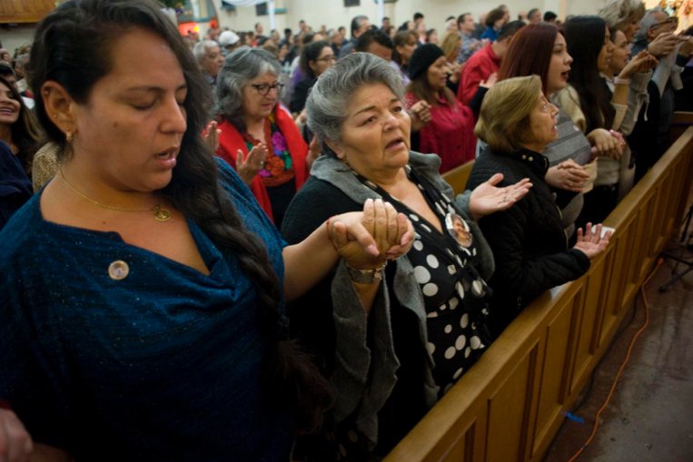 Worshippers recite the Lord's Prayer during a Mass celebrated in honor of the 100th anniversary of Our Lady of Guadalupe Church Dec. 9 in San Diego.