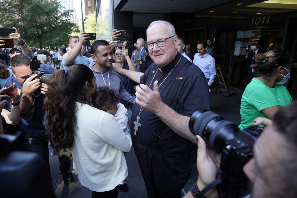 New York Cardinal Timothy M. Dolan greets a family from Venezuela seeking asylum in the U.S. prior to a news conference outside the Archdiocese of New York's headquarters in New York City Aug. 16, 2022.