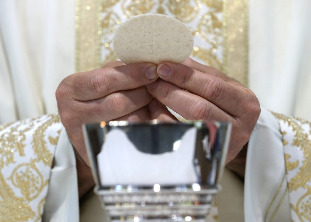 A priest holds the Eucharist in this illustration.