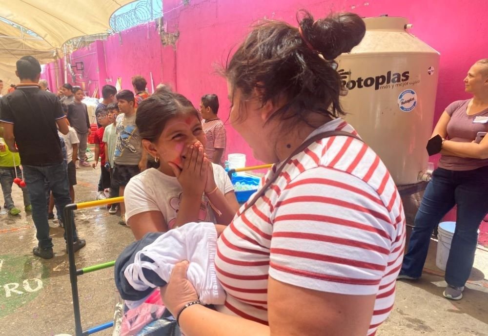 Una mujer migrante y su hija se sorprendieron al ver dinero dentro de una cartera, un regalo de las religiosas y sus amigas, que visitaron a los migrantes en el albergue Cobina en Mexicali, México, el 10 de mayo de 2023. La visita fue facilitada por la organización sin fines de lucro Border Compassion, que organiza encuentros interreligiosos con migrantes.