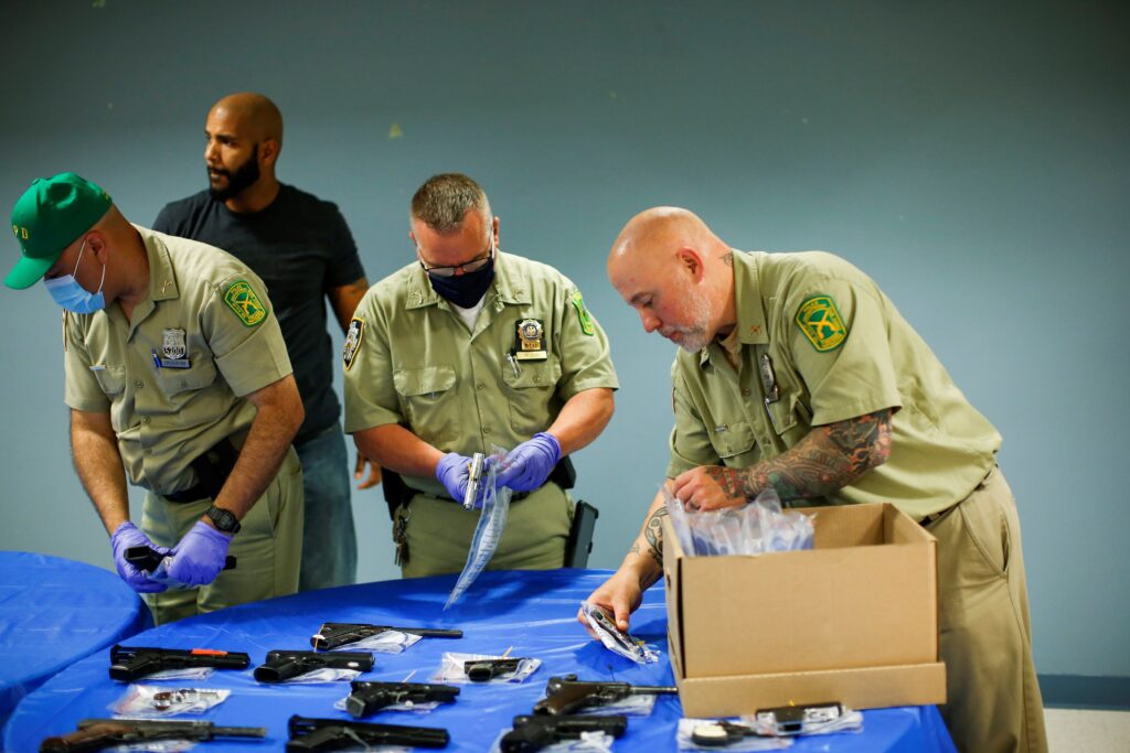 New York Police officers package guns after a gun buyback event organized by the New York Police Department in the Queens borough June 12, 2021.