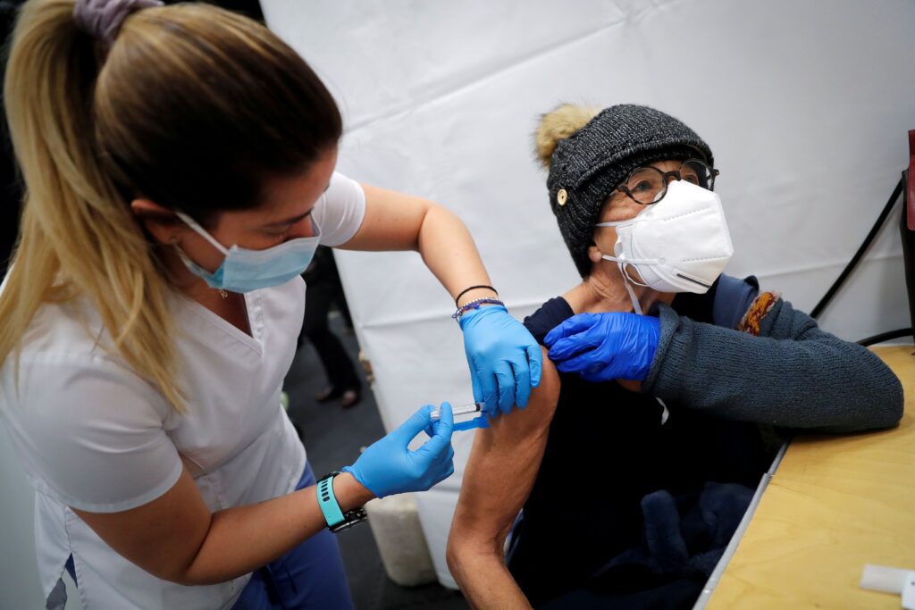 A health care worker in New York City administers a shot of the Moderna COVID-19 vaccine to a woman at a pop-up vaccination site Jan. 29, 2021.
