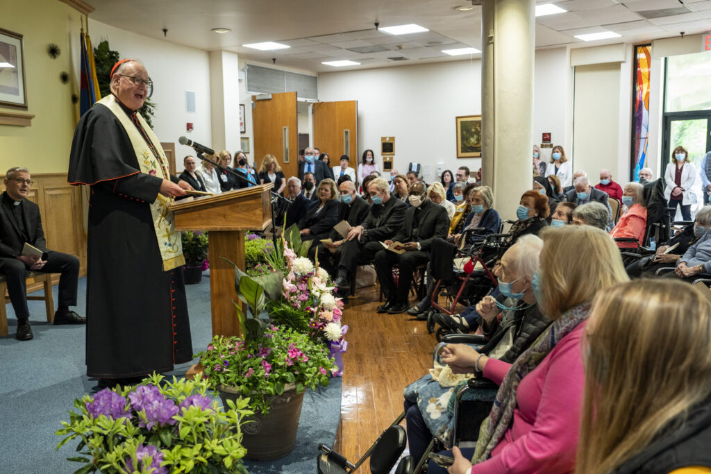 Cardinal Timothy Dolan (left) leads the staff and residents of Eger Health Care and Rehabilitation Center on Staten Island in a prayer service, May 10, 2023.