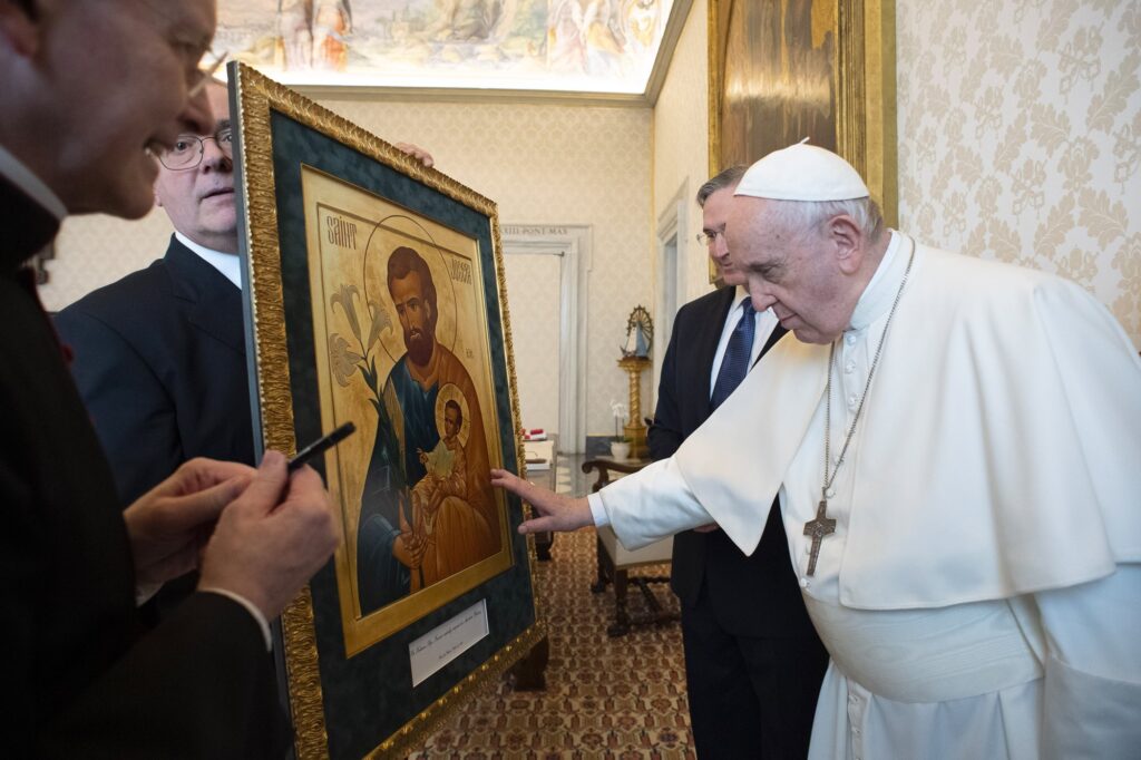 Pope Francis touches an icon of St. Joseph and the Christ Child presented to him by Supreme Knight Patrick Kelly, standing next to the pope, during a private audience at the Vatican Oct. 25, 2021. Kelly, as head of the Knights of Columbus, congratulated Pope Francis on his 10th anniversary as spiritual leader of the Catholic Church March 13, 2023, and invited Catholics to participate in a novena to St. Joseph for the pontiff. March 12 to March 20, when the feast of St. Joseph is observed in 2023 because with the March 19 solemnity will fall on Sunday.