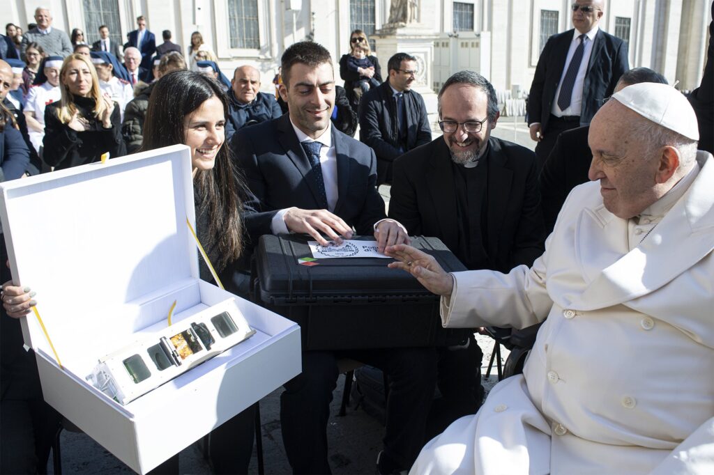 During his general audience at the Vatican March 29, 2023, Pope Francis blesses "Spei Satelles," a small CubeSat satellite that was launched into space June 12, 2023. The satellite carries a "nano" version of his book, "Why Are You Afraid? Have You No Faith?"