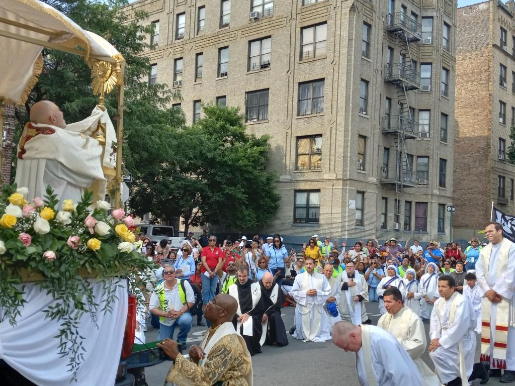 Auxiliary Bishop Joseph Espaillat holds up a monstrance with the Blessed Sacrament in one of several brief adorations during the June 11, 2023, Corpus Christi Sunday procession on the Grand Concourse in the Bronx.