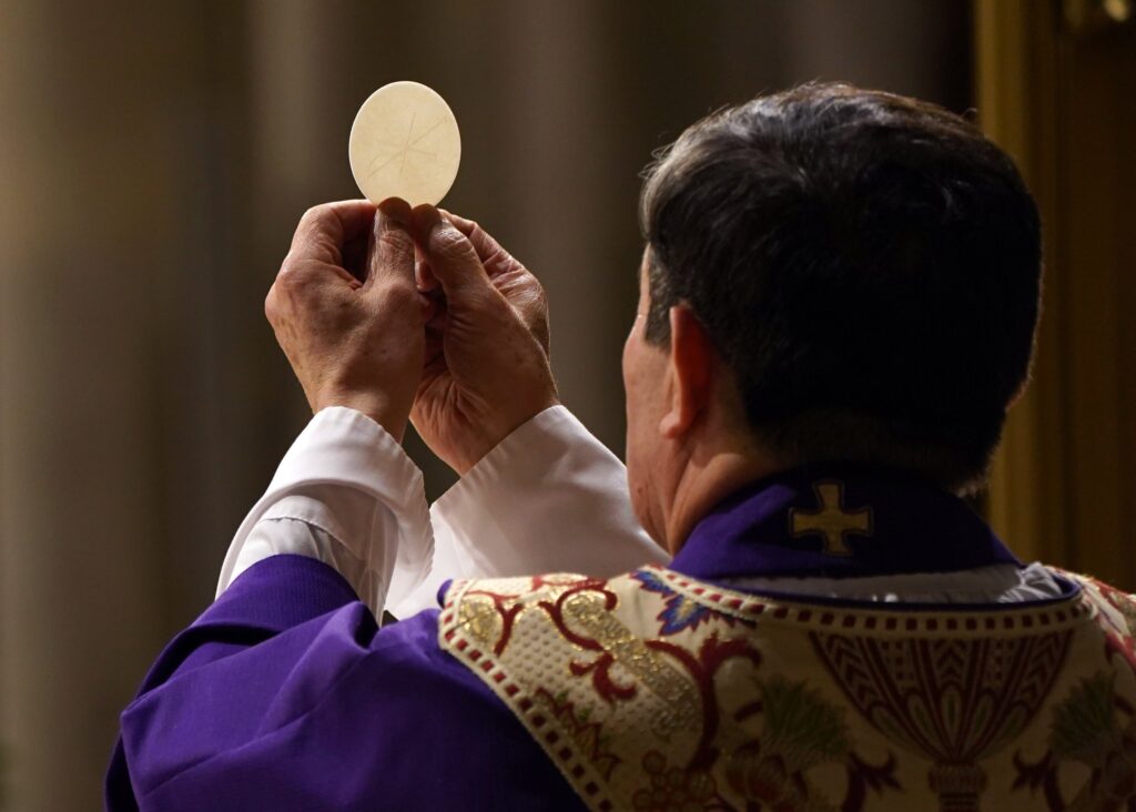 A priest elevates the host during a Mass at St. Patrick's Cathedral in New York City in 2020.