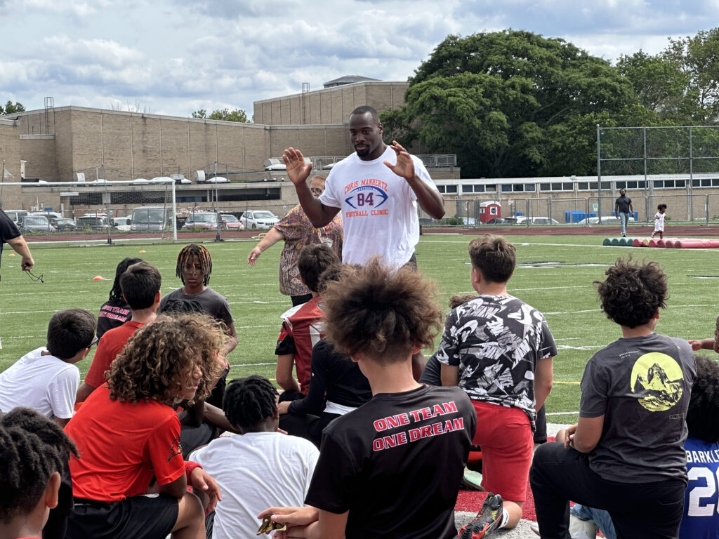 Denver Broncos tight end and Cardinal Spellman High School alumnus Chris Manhertz (center) leads a football clinic at Cardinal Spellman High School, July 10, 2023.