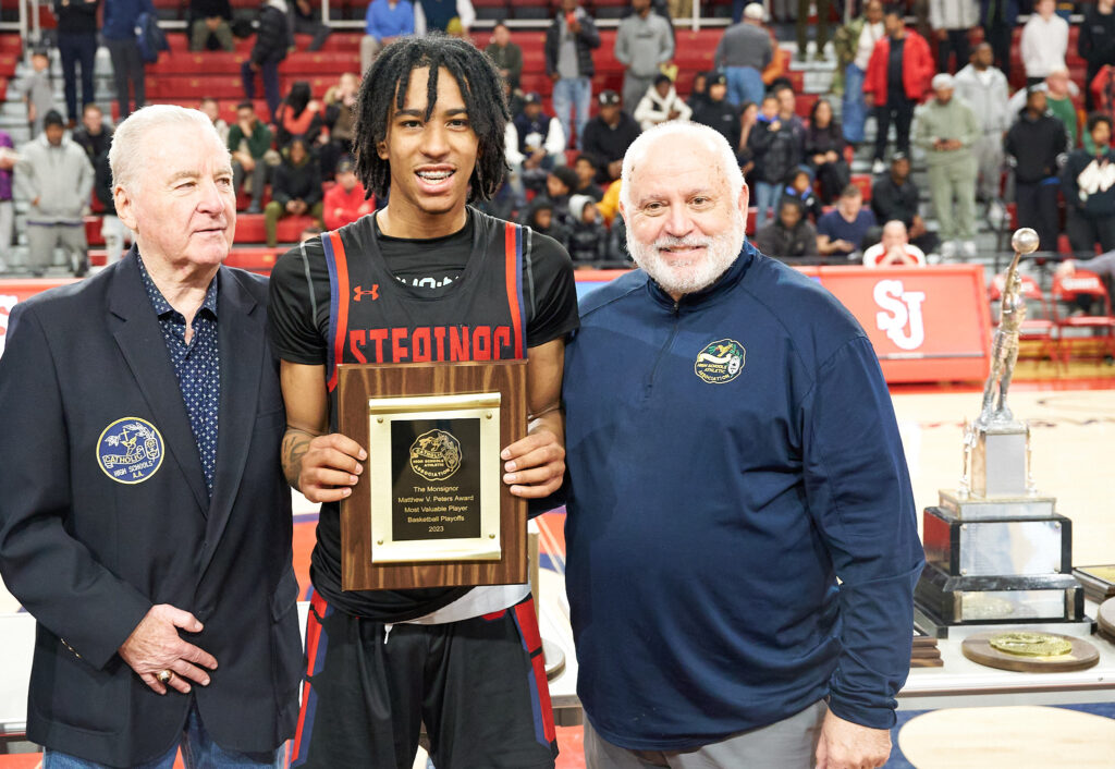 Johnuel "Boogie" Fland (center) poses with his award for most valuable player of the New York Catholic High School Athletic Association playoffs in March 2023.