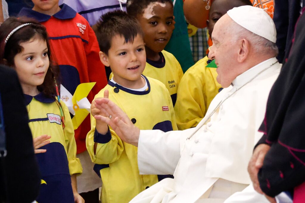 Pope Francis greets children after meeting with representatives of local charities at the parish center in Serafina, a neighborhood in Lisbon, Portugal, Aug. 4, 2023.