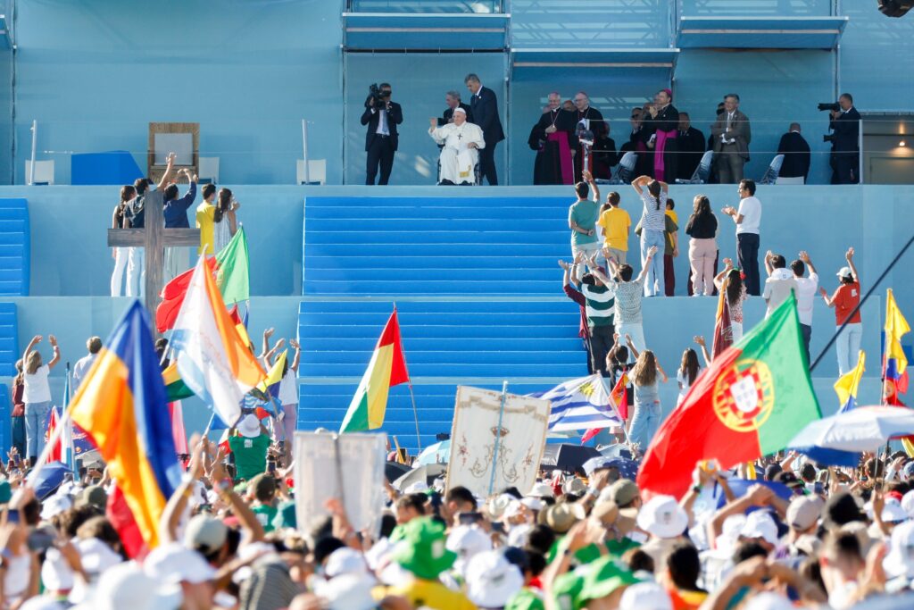 Pope Francis greets young people from the stage as he arrives to preside over the World Youth Day Stations of the Cross with young people at Eduardo VII Park in Lisbon, Portugal, Aug. 4, 2023.