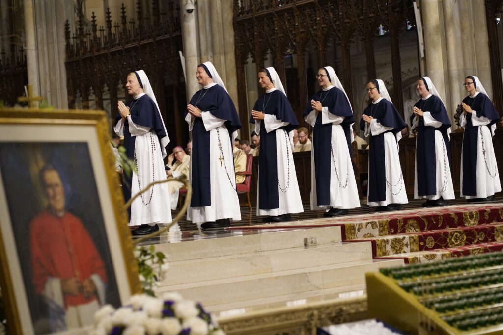 Sisters of Life Mary Pieta, left, Mercy Marie, Mary Grace, Fidelity Grace, Zelie Maria Louis, Ann Immaculee and Catherine Joy Marie stand in the sanctuary as they prepare to profess their perpetual vows during a special Mass at St. Patrick’s Cathedral in New York City Aug. 5, 2023.