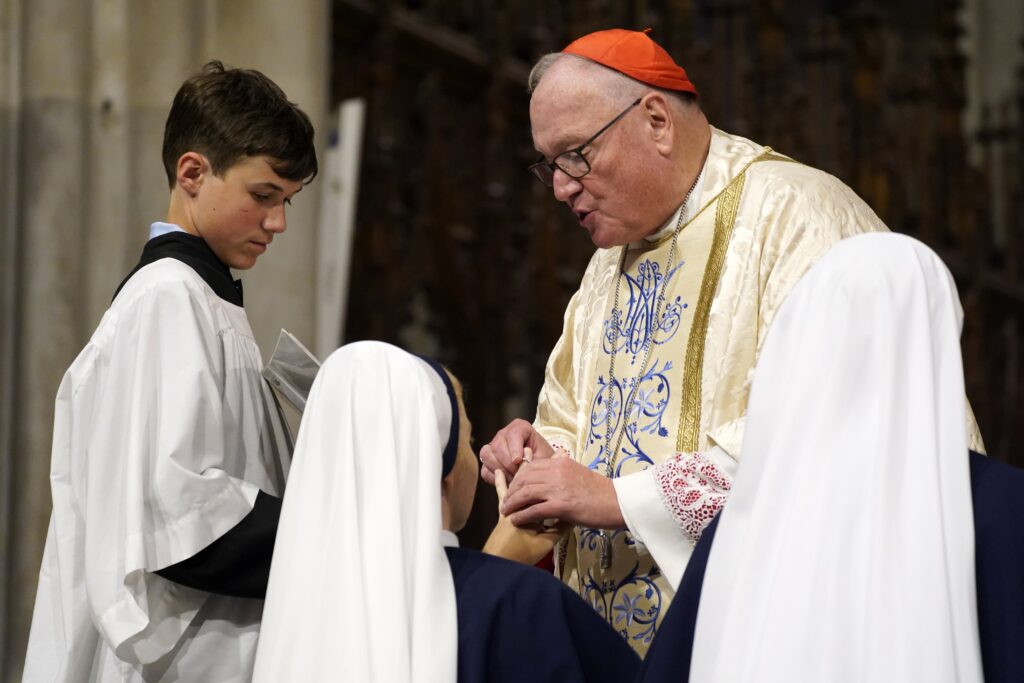 New York Cardinal Timothy M. Dolan places a ring on the finger of Sister Mary Pieta after she and six other members of the Sisters of Life professed their perpetual vows during a special Mass at St. Patrick’s Cathedral in New York City Aug. 5, 2023.