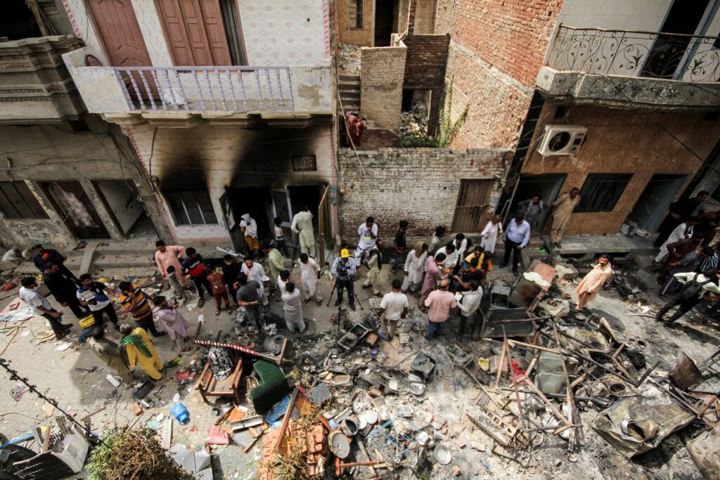 Residents gather along a street in the Christian neighborhood of Jaranwala, Pakistan, Aug. 17, 2023, a day after church buildings and houses were vandalized by protesters.