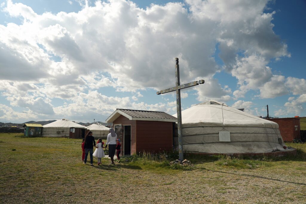 Sister Theodora Mbilinyi walks with children outside a Catholic church at Our Mother of Mercy Mission on the outskirts of Arvaikheer city, Mongolia, Aug. 28, 2023.