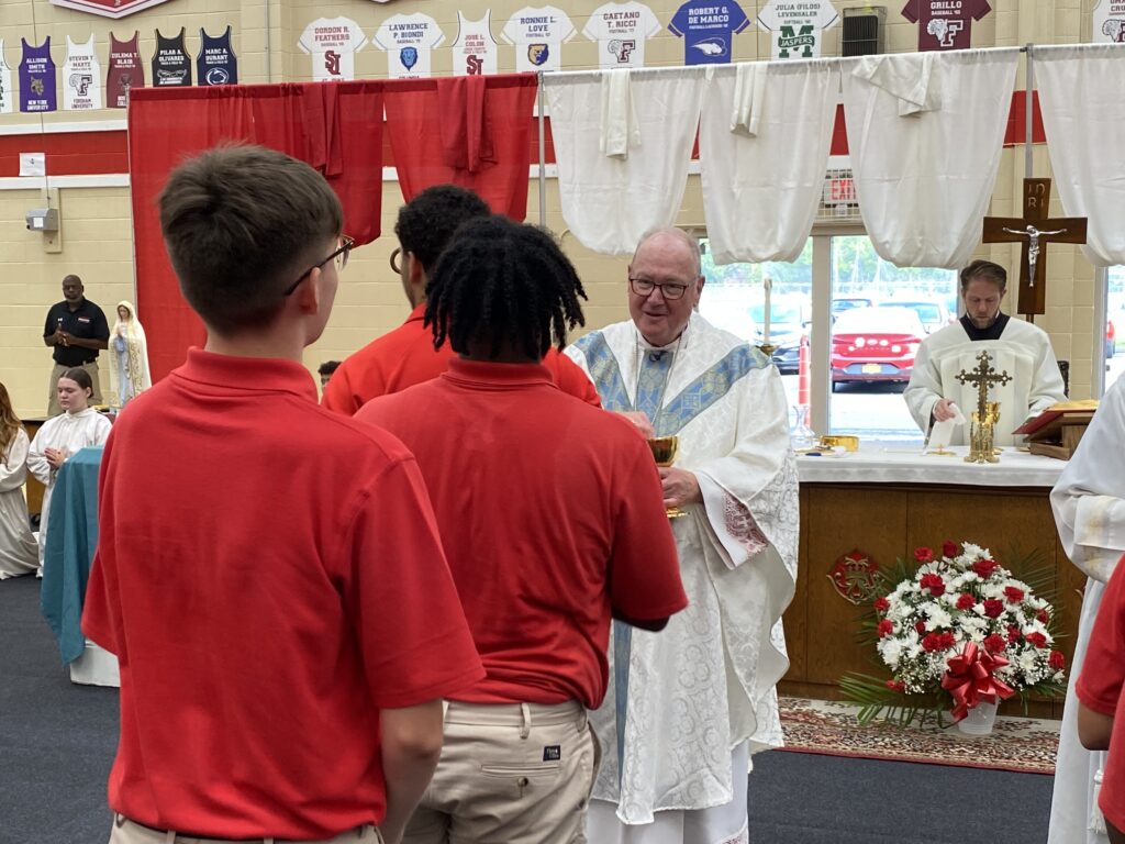 Cardinal Timothy Dolan (center) offers communion to students of Cardinal Spellman High School in The Bronx, September 8, 2023.