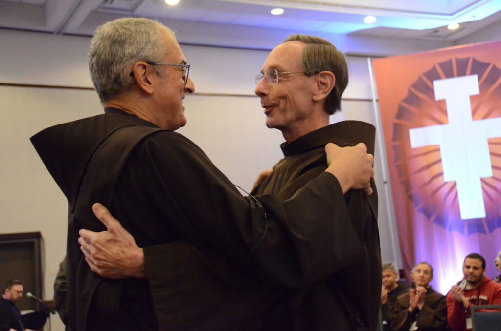 Franciscan Brothers Massimo Fusarelli, minister general of the Order of Friars Minor, and Lawrence Hayes, embrace after Brother Hayes was installed as provincial minister at the newly unified Province of Our Lady of Guadalupe on October 17, 2023, during a meeting in Kansas City, Mo. The new province, based in Atlanta, unifies six legacy provinces, which were established over the long history of the Order of Friars Minor in the United States.