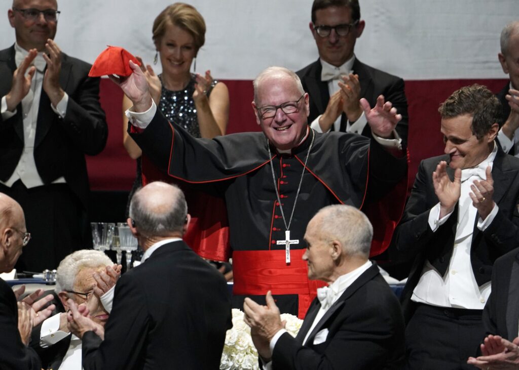 New York Cardinal Timothy M. Dolan waves to the audience after being introduced at the 78th annual Alfred E. Smith Memorial Foundation Dinner at the Park Avenue Armory in New York City on October 19, 2023.