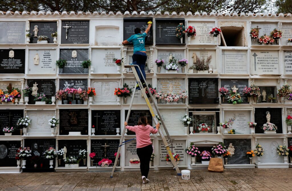 A man cleans the tombstone of his relative at a cemetery, days before All Saints' Day in Ronda, Spain, October 29, 2023.