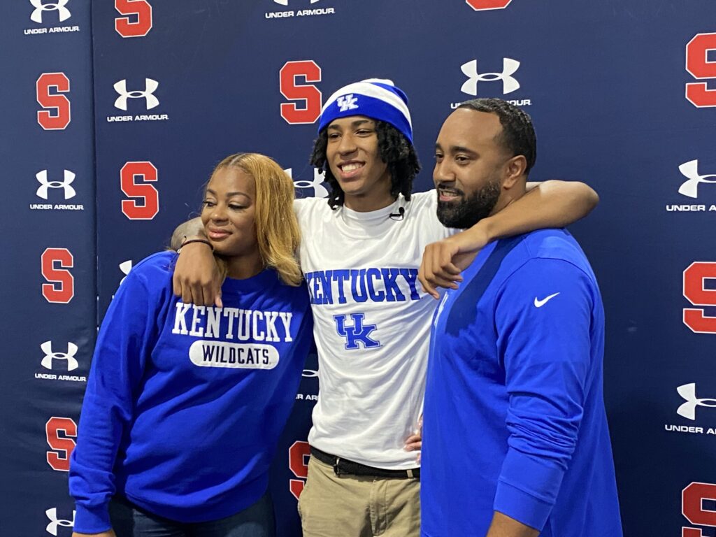 Archbishop Stepinac High School student Johnuel "Boogie" Fland (center) poses with his parents after announcing that he will attend the University of Kentucky next year. Fland is considered one of the high school class of 2024's top basketball players, and the best point guard in the country.