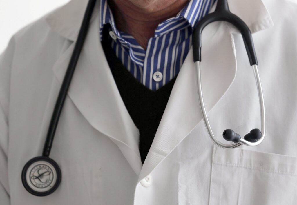 A photo illustration shows a general practitioner with a stethoscope.