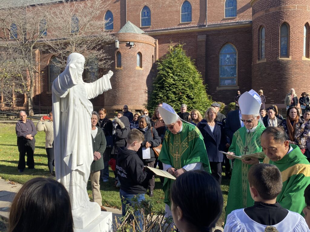 Archdiocese of New York Auxiliary Bishop Peter Byrne (center right) leads the re-blessing of a state of the Sacred Heart at Sacred Heart Church on Castleton Avenue in Staten Island, November 19, 2023.