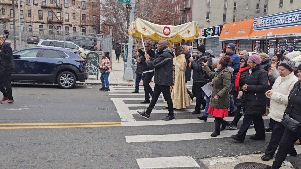 Father Ambrose Madu (center, in gold vestments) leads parishioners of Christ The King Church on a procession through The Bronx on Sunday, November 26, 2023.