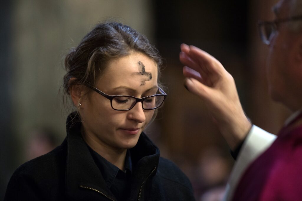 A woman is pictured in a file photo receiving ashes during Ash Wednesday Mass. Ash Wednesday falls on Valentine's Day in 2024.