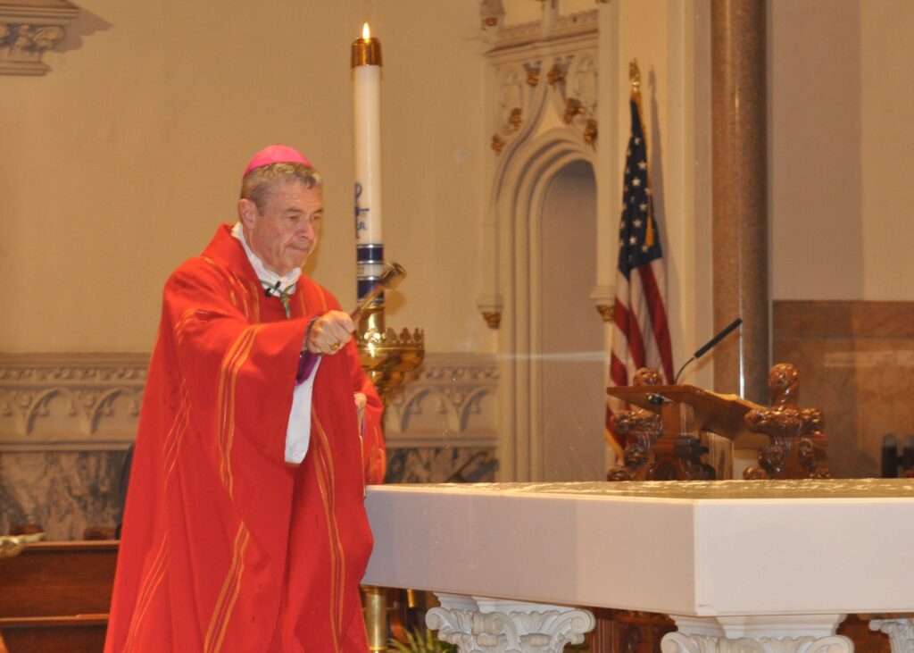 Bishop Robert J. Brennan of Brooklyn blesses and purifies the altar at St. Augustine Church on June 4, 2022.