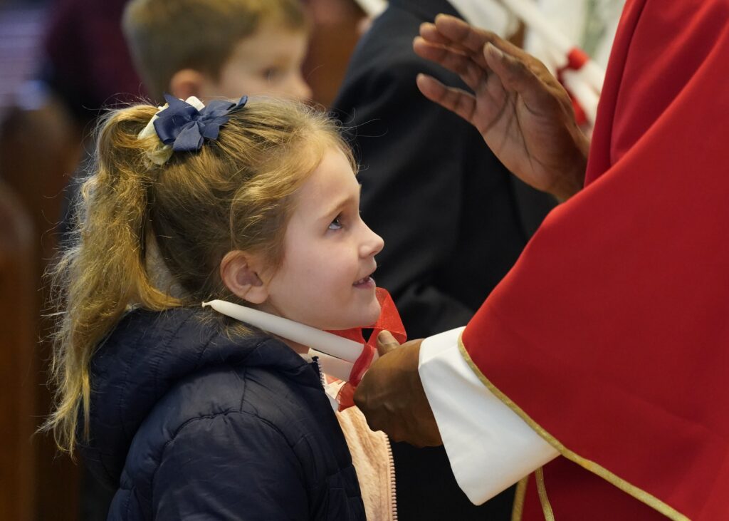 Elizabeth Koromi, a first-grade student at St. Patrick Parish School in Smithtown, N.Y., has her throat blessed by Father Abraham Thannickal following a Mass celebrated on February 3, 2023, in observance of the feast of St. Blaise.