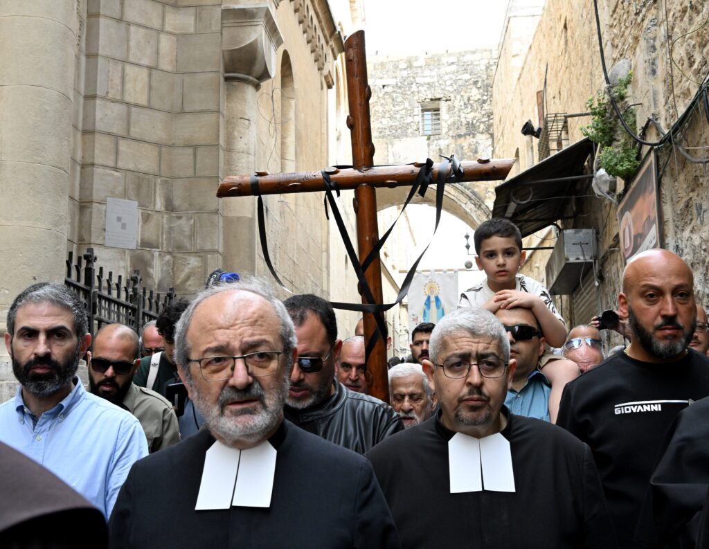 Palestinian Catholics from St. Savior's Parish carry a cross on the Via Dolorosa, the Way of the Cross, on Good Friday in the Old City of Jerusalem, March 29, 2024.