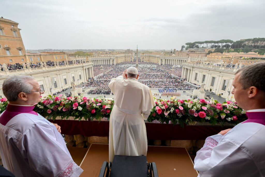 Pope Francis greets the crowd after delivering his Easter message and blessing "urbi et orbi" (to the city and the world) from the central balcony of St. Peter's Basilica at the Vatican on March 31, 2024.