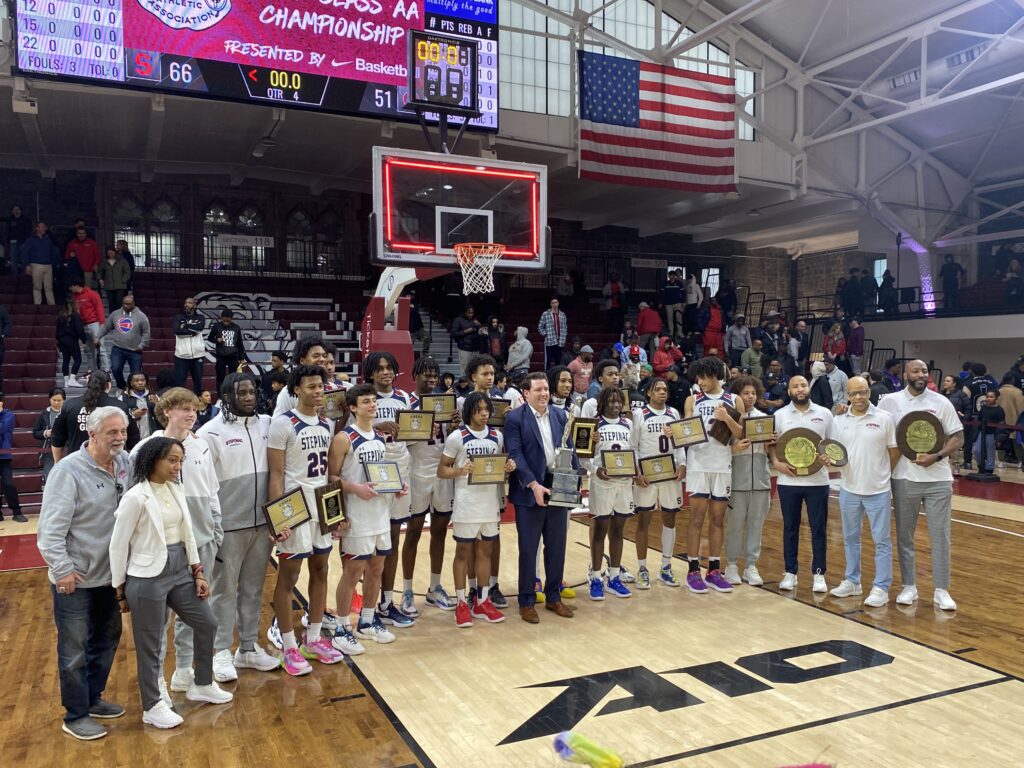 Archbishop Stepinac High School Crusaders boys’ varsity basketball players and coaches pose with their trophies, after winning their second consecutive CHSAA City Intersectional “AA” title.