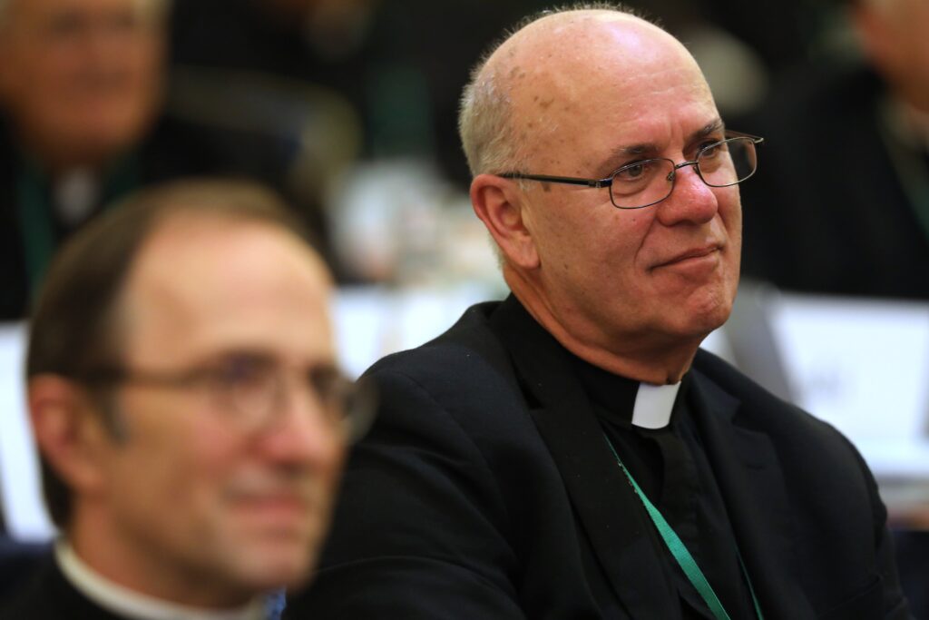 Bishop Kevin C. Rhoades of Fort Wayne-South Bend, Indiana, right, smiles during a November 15, 2022, session of the fall general assembly of the U.S. Conference of Catholic Bishops in Baltimore.