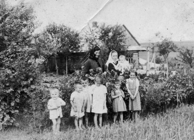 Wiktoria Ulma (con un niño en brazos) con sus seis hijos delante de su casa en Markowa, Polonia, en esta foto sin fecha. (Se desconoce la identidad de la mujer que está junto a Wiktoria.) La familia Ulma y los judíos que albergaban fueron asesinados por los alemanes el 24 de marzo de 1944, cuando los ocupantes nazis fueron informados de que había judíos refugiados en su casa.