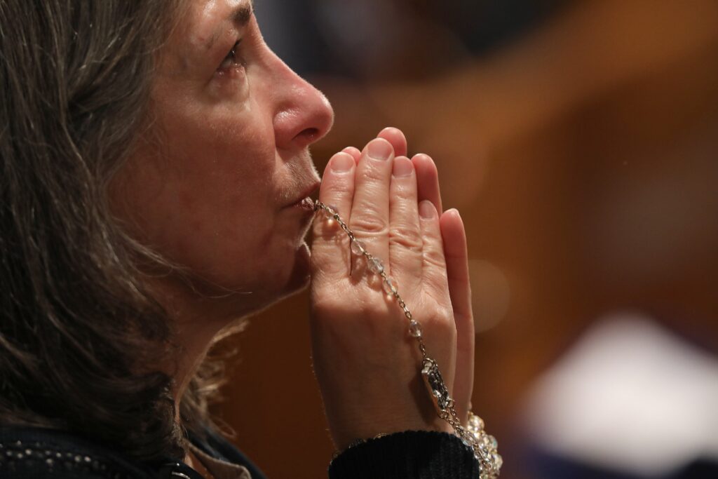 A woman becomes emotional as she prays with a rosary during Eucharistic adoration following the opening Mass of the National Prayer Vigil for Life January 19, 2023, at the Basilica of the National Shrine of the Immaculate Conception in Washington.