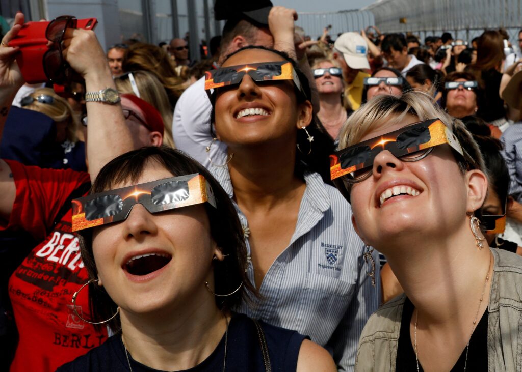 People watch the solar eclipse from the observation deck of The Empire State Building in New York City Aug. 21, 2017.